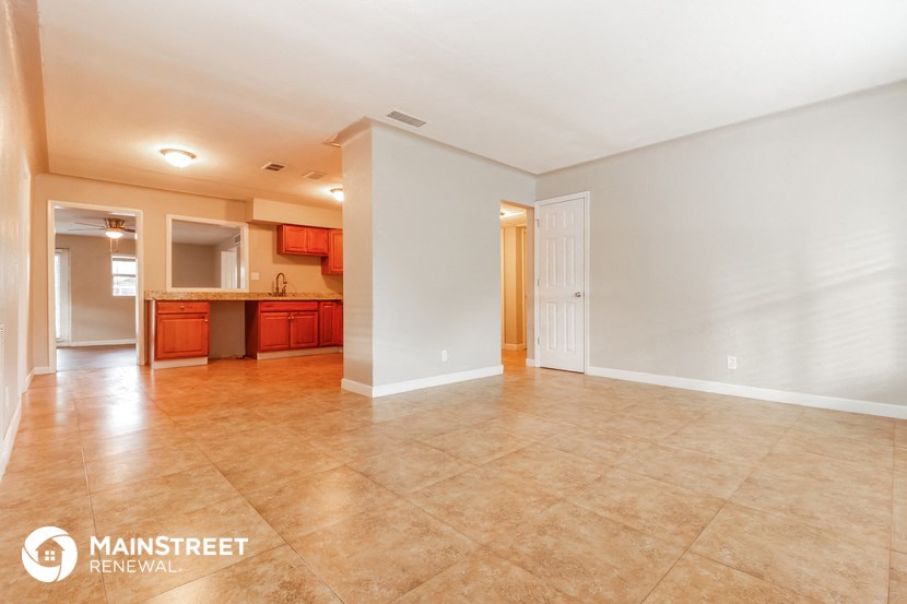 the living room and kitchen are spacious with tile floors and white walls