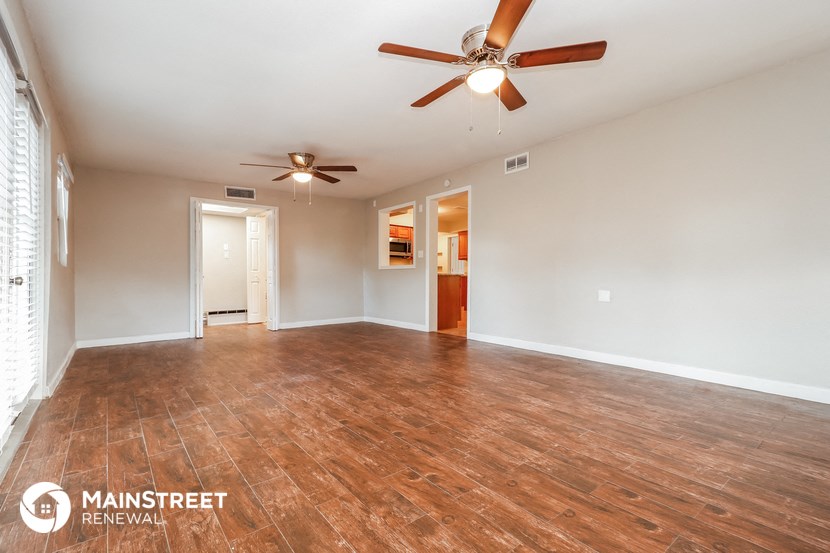 the living room and dining room with wood flooring and ceiling fan
