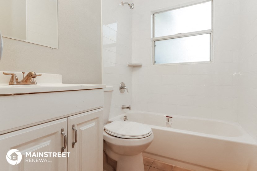 a bathroom with a toilet and a tub and a sink
