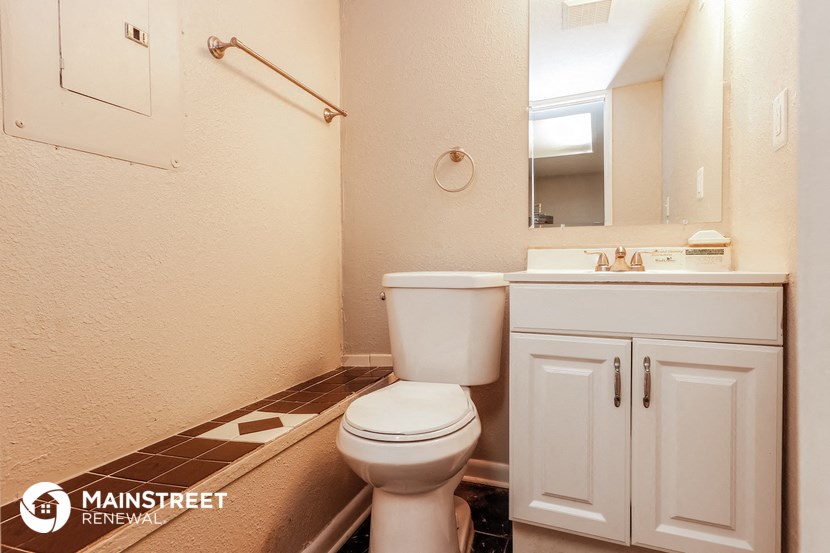 a bathroom with a toilet and a sink and a mirror