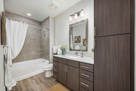 A bathroom with a white toilet, a white sink, and a white shower curtain.