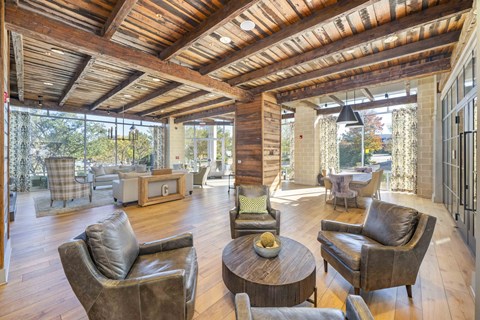 A living room with a wooden ceiling and brown leather chairs.