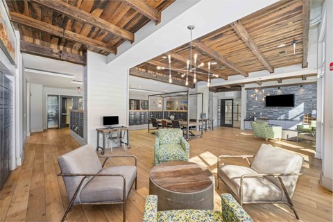 A living room with a wooden floor and a stone fireplace.