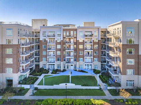 A large apartment complex with a green lawn in the front.