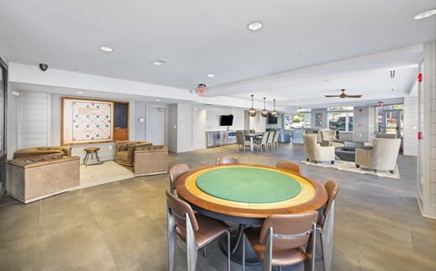 A room with a green table surrounded by chairs.