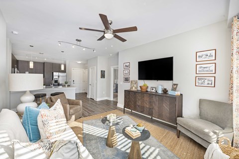 A living room with a couch, a coffee table, and a ceiling fan.