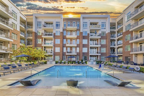 A large swimming pool in front of apartment buildings.