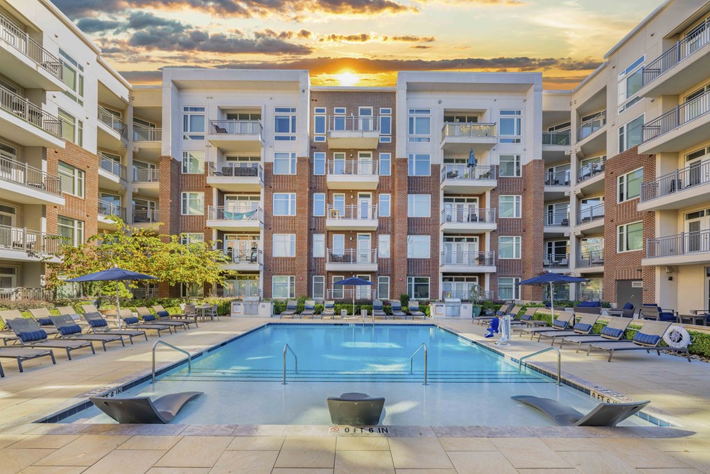 A large swimming pool in front of apartment buildings.