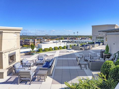 A rooftop patio with furniture and a view of the city.