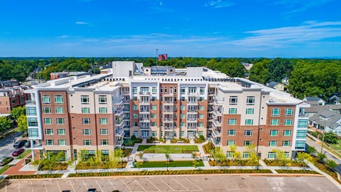 an aerial view of a large apartment building with trees in the background