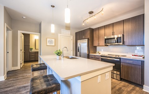 a kitchen with a large island and black appliances