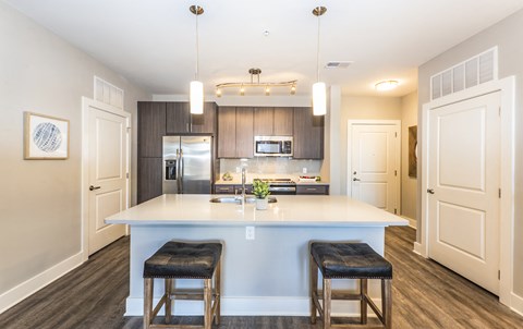 a kitchen with a large island with two stools