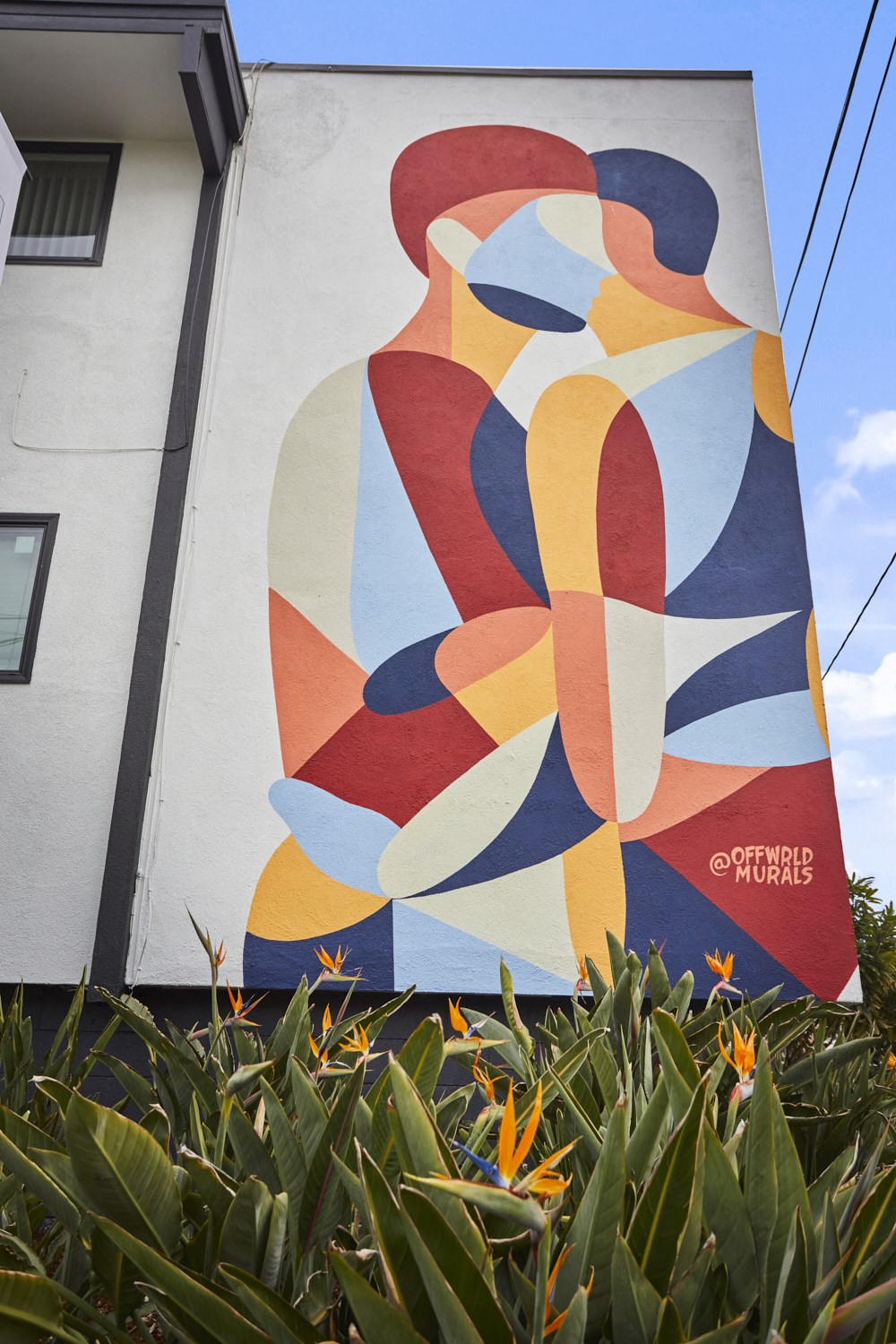 Building exterior abstract mural of two people embracing
