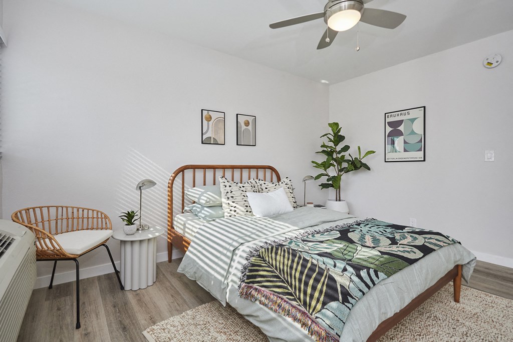 Bedroom with full bed and chair and small table next to window