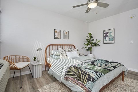 Bedroom with full bed and chair and small table next to window