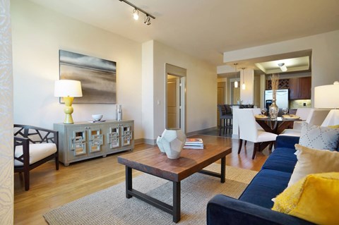 A living room with a blue couch and a wooden coffee table.