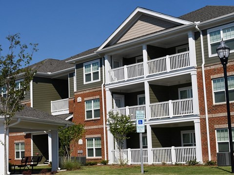 Apartment building with a blue sign on the railing.