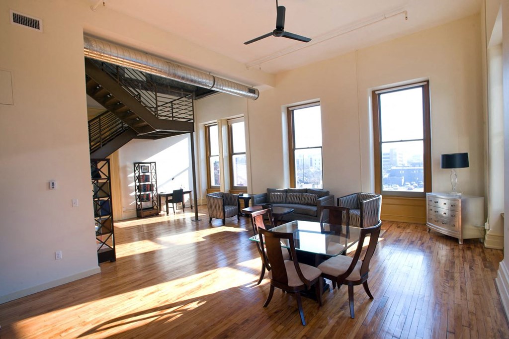 an empty living room with a dining room table and chairs