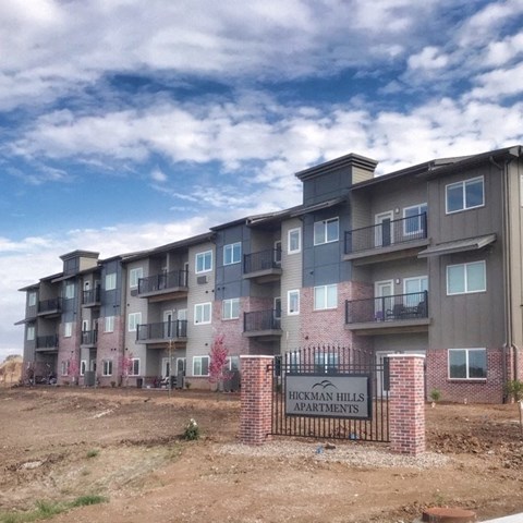 an apartment building with a sign in front of it
