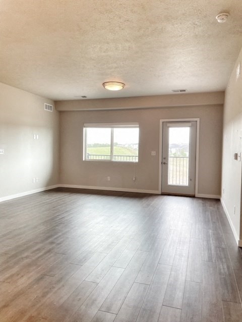 an empty living room with wood floors and a door