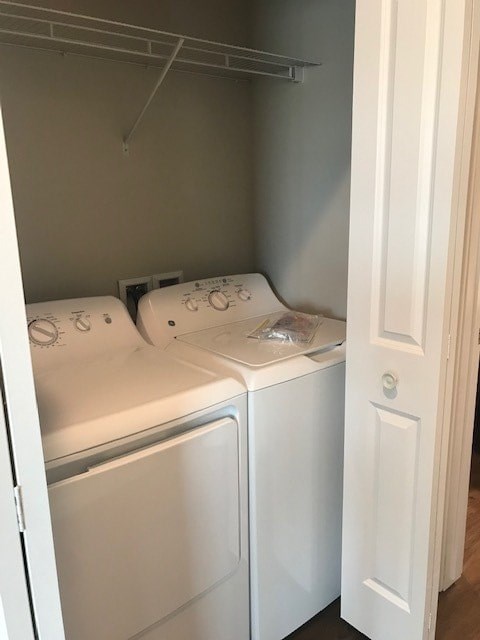 Two white front loading washing machines in a small laundry room.