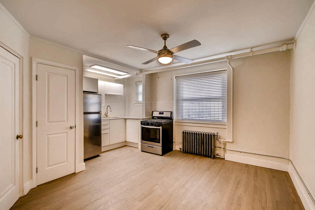 an empty kitchen with a ceiling fan and a window