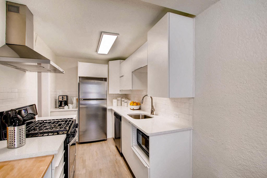 a kitchen with white cabinets and stainless steel appliances
