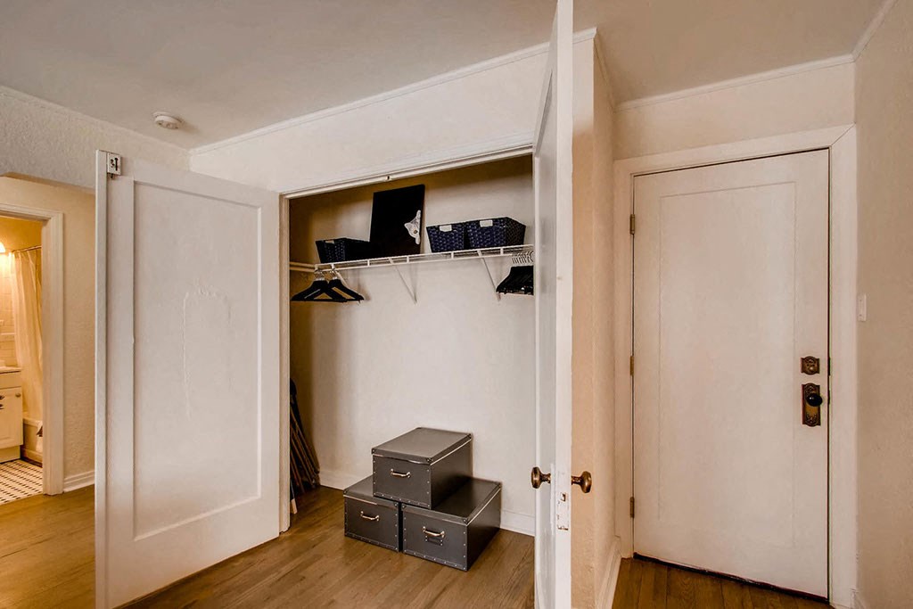 a bedroom with a closet and a door to a hallway with a wardrobe and a