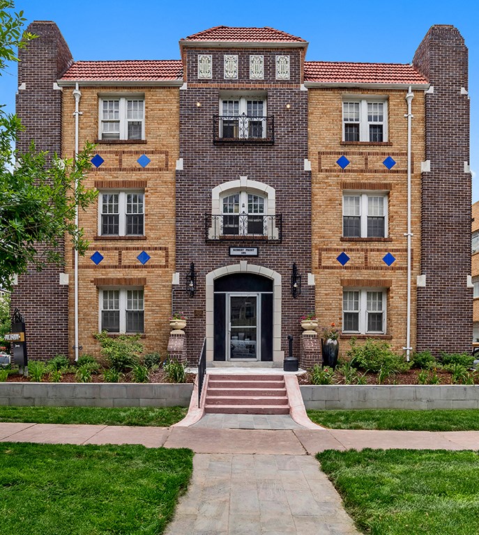 a large brick building with a sidewalk in front of it