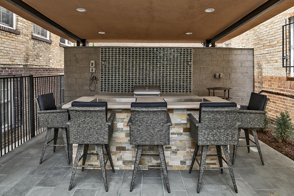 a large outdoor patio with a bar and seating area with stools