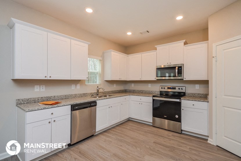a kitchen with white cabinets and stainless steel appliances