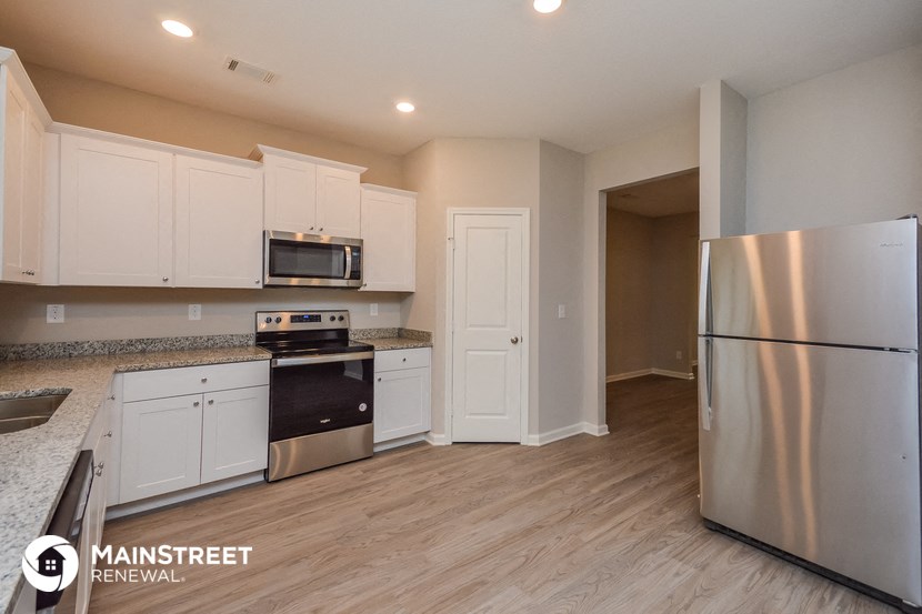 a kitchen with white cabinets and stainless steel appliances