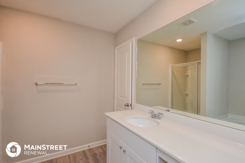 a white bathroom with a sink and a mirror