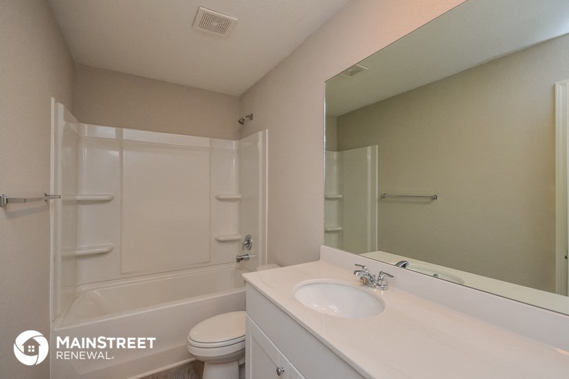 a bathroom with a sink and a shower and a mirror
