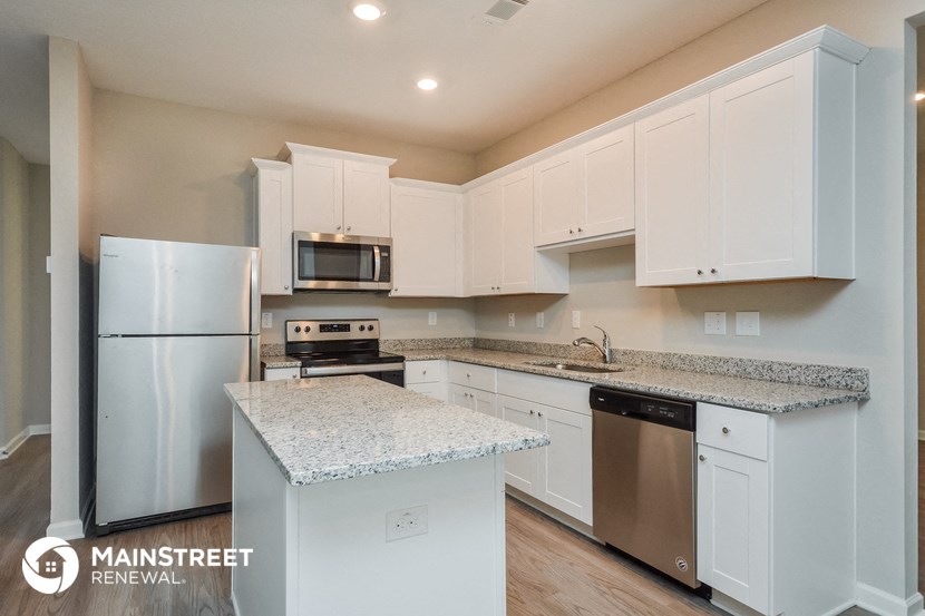 a white kitchen with granite counter tops and stainless steel appliances
