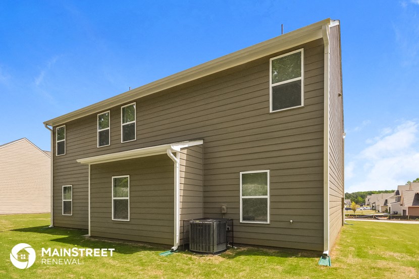 the exterior of a home with brown siding and a trash can