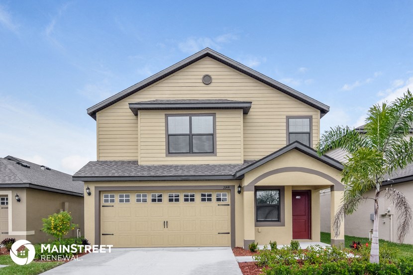 a beige house with a garage and a driveway