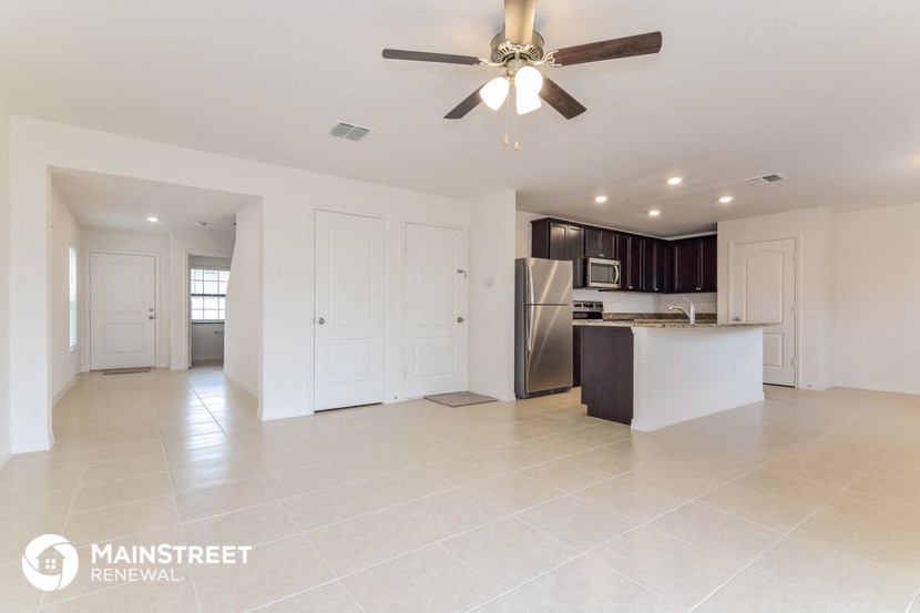 an open kitchen and living room with a ceiling fan