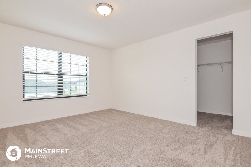 an empty living room with a window and a closet