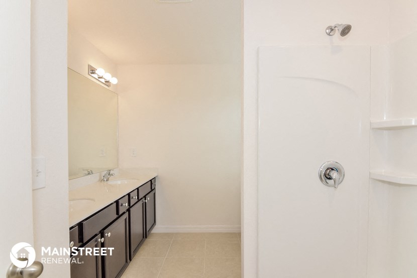 a bathroom with a shower and a sink and a mirror