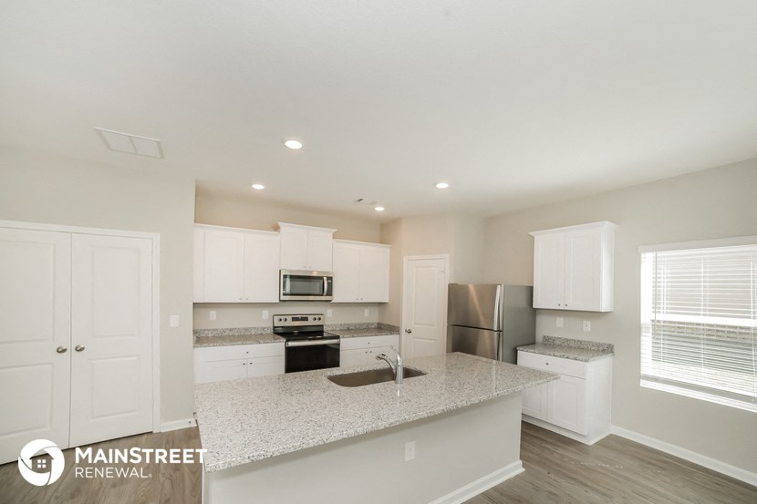 a kitchen with white cabinets and a granite counter top