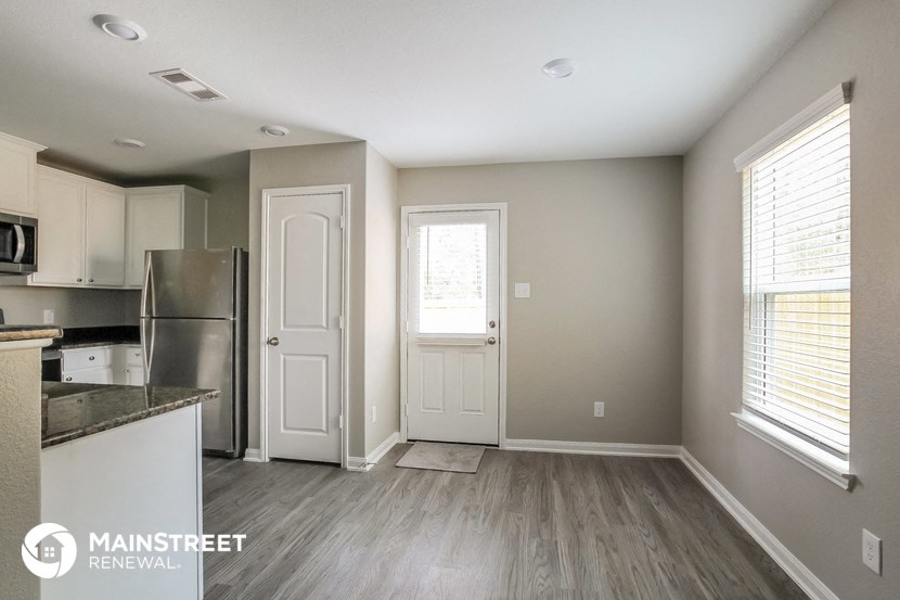 a renovated kitchen with white cabinets and stainless steel appliances