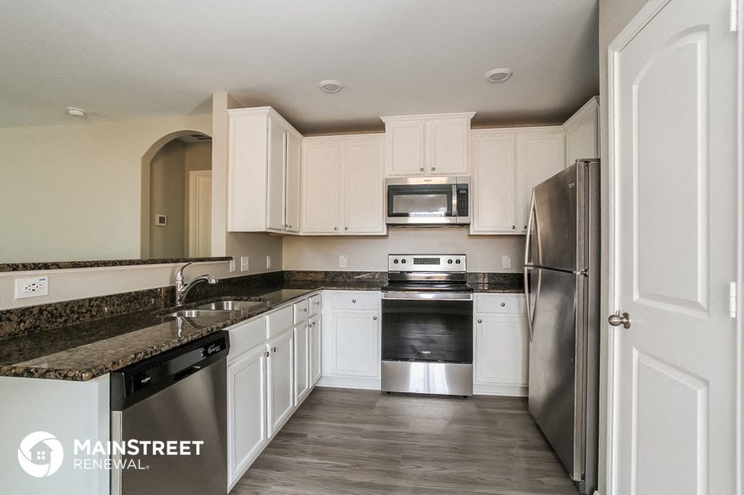 a kitchen with white cabinets and stainless steel appliances