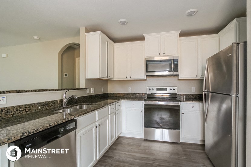 a kitchen with white cabinets and stainless steel appliances