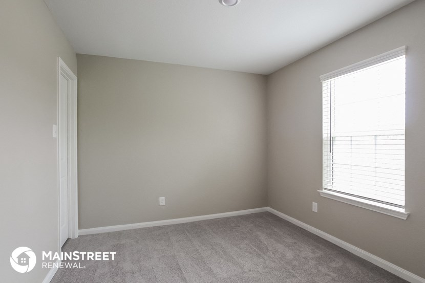 a bedroom with a carpeted floor and two windows