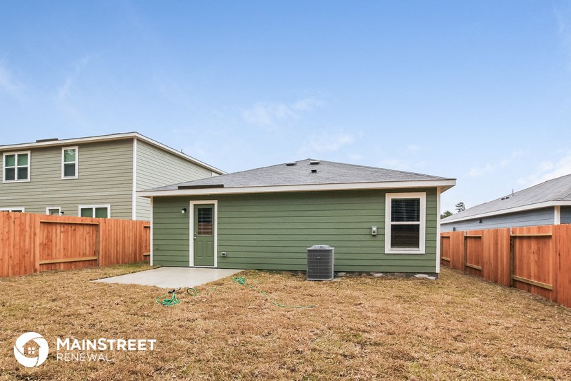a backyard with a green house and a wooden fence