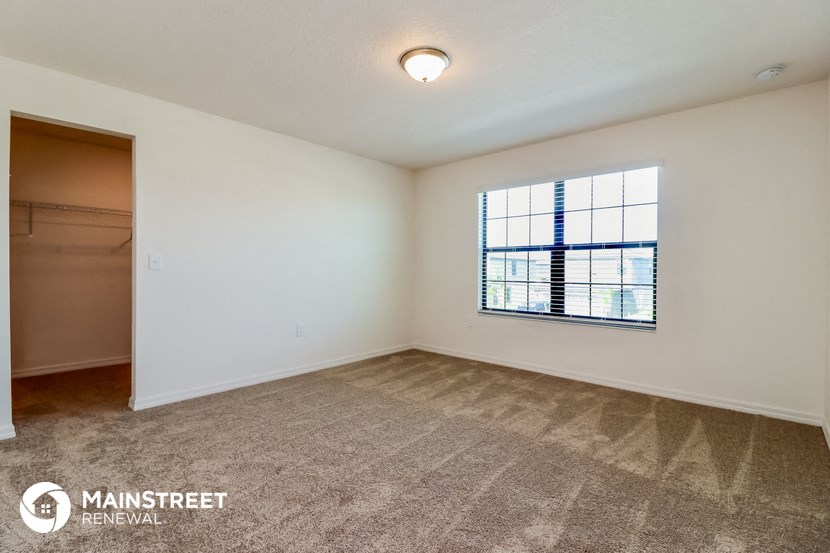 an empty living room with a window and a closet