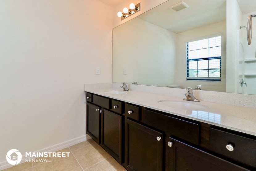 a bathroom with two sinks and a large mirror
