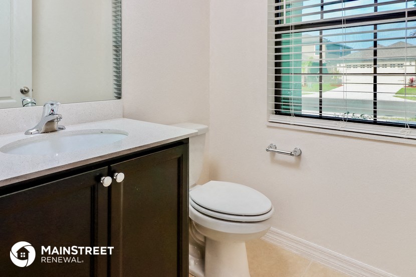 a bathroom with a toilet and a sink and a window