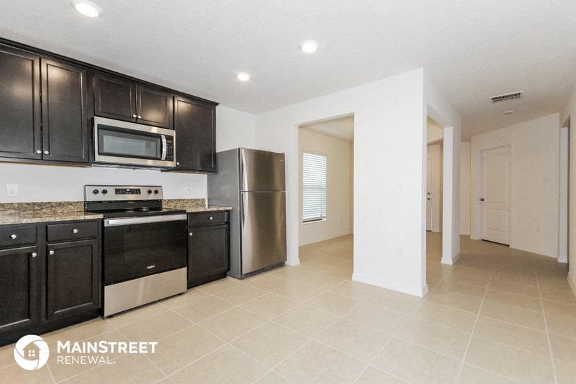 a kitchen with black cabinets and stainless steel appliances